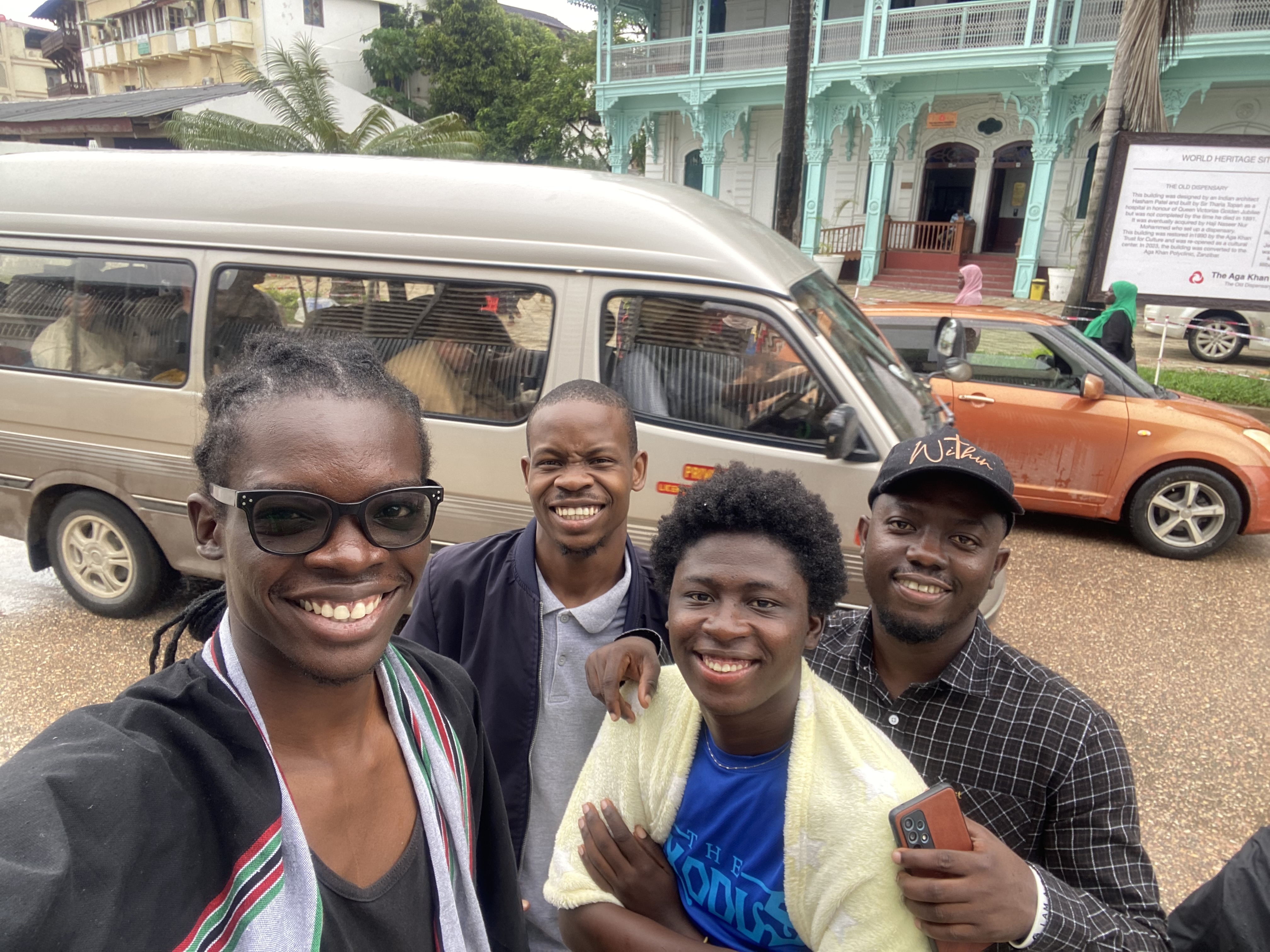 Four friends smiling for a selfie outside the DjangoCon Africa venue
